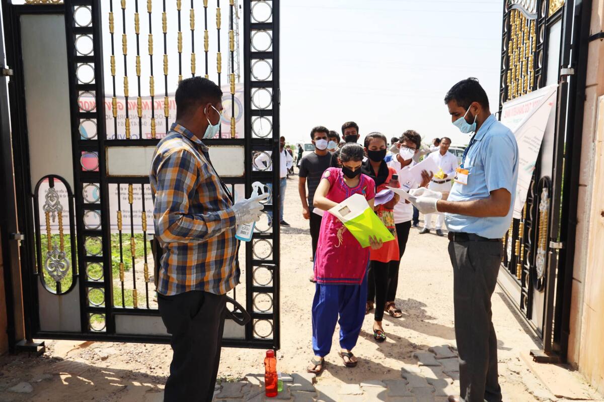 Il virus Nipah mette in allarme l'India - Jodhpur, Rajasthan, India, September 13,2020: Students go through sanitation process before entering in examination center, safety measures taken by the college or school staff due to covid-19