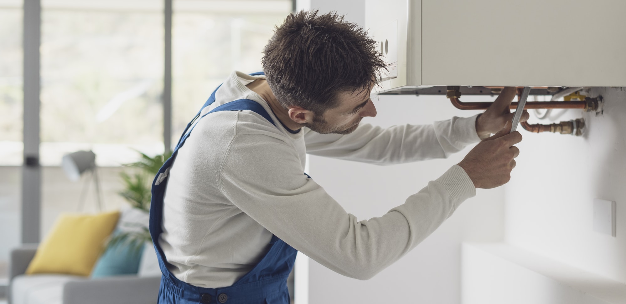 Professional plumber checking a boiler and pipes, boiler service concept