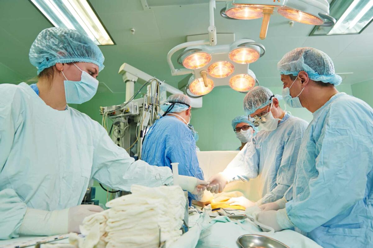 Trapiantato un cuore fermo da 20 minuti al Sant'Orsola - Team of surgeon in uniform perform heart transplantation operation on a patient at cardiac surgery clinic