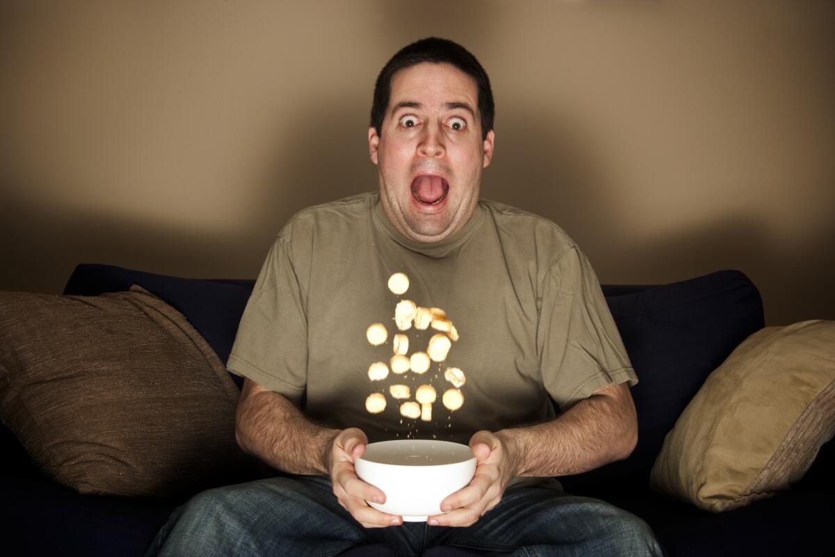 I 20 film horror più spaventosi di sempre - Man throws crisps frightened while watching horror movie