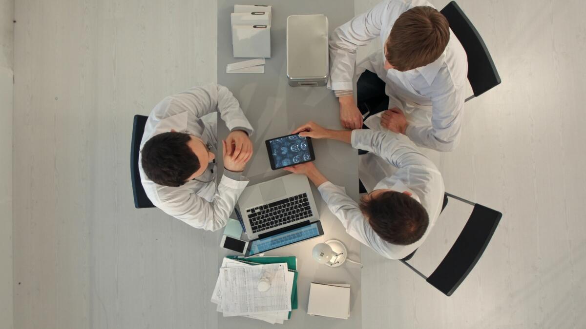 La Federazione Italiana Medici Pediatri sconsiglia l'uso del web per i bambini fino a 9 anni di età - Group of happy doctors with tablet pc computers meeting at medical office. Top view. Professional shot on BMCC RAW fith high dynamic range. You can use it e.g in your commercial video, commercial video, medical ,video about clinic, doctor, health, ho