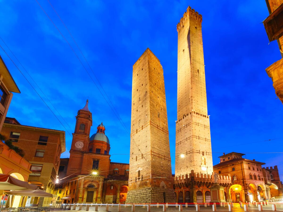 Le Due Torri di Bologna rischiano di crollare - Two Towers, Asinelli and Garisenda, both of them leaning, symbol of Bologna, statue of San Petronius and Church of Saints Bartholomew and Gaetano in the morning, Bologna, Emilia-Romagna, Italy