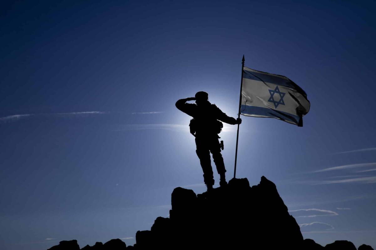 Missile di Hamas scoppia vicino all’aeroporto di Tel Aviv: Ryanair chiede la chiusura dello spazio aereo - Soldier on top of the mountain with the Israeli flag