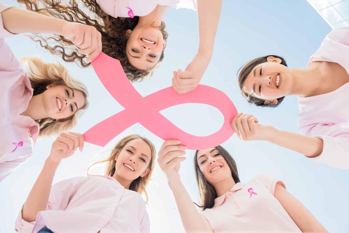 Una ricerca rivela che vi è correlazione tra il tumore al seno e l'inquinamento atmosferico - Hands joined in circle holding breast cancer struggle symbol.
