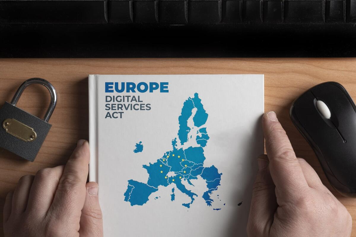 Cos'è il Digital Services Act (DSA)? - Digital services act concept: man hold a book with european union shape and the text Europe digital services act
