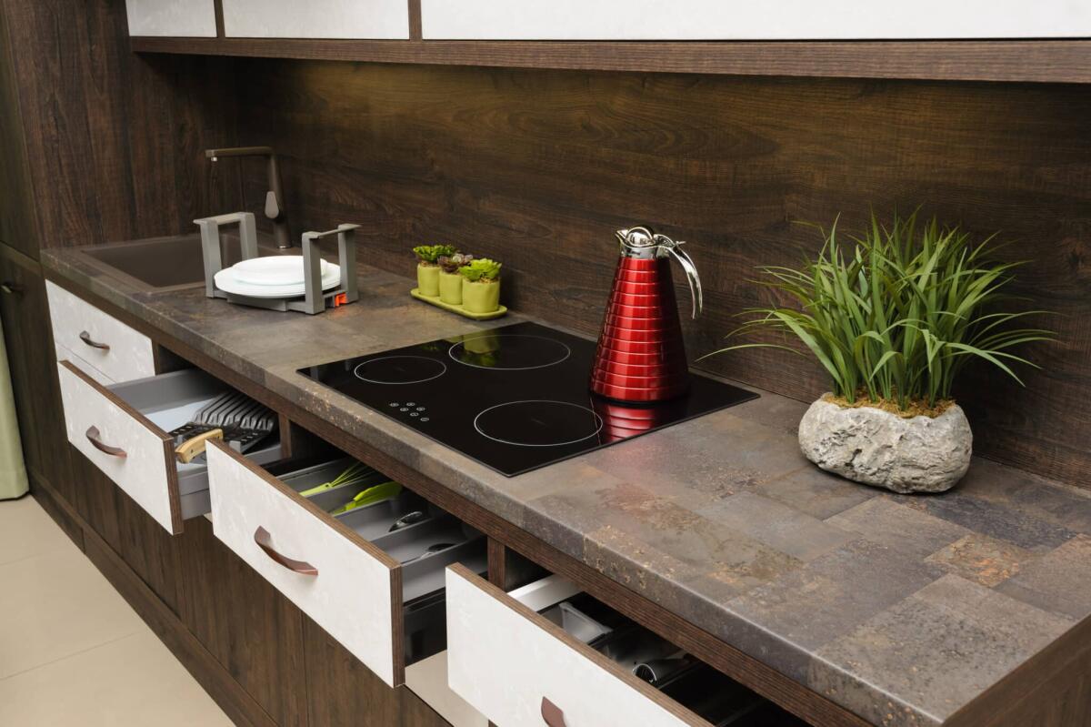 Cucinare con le piastre a induzione fa male? - Luxury cozy modern dark brown kitchen, induction stove, minimalistic clean design. some drawers are open