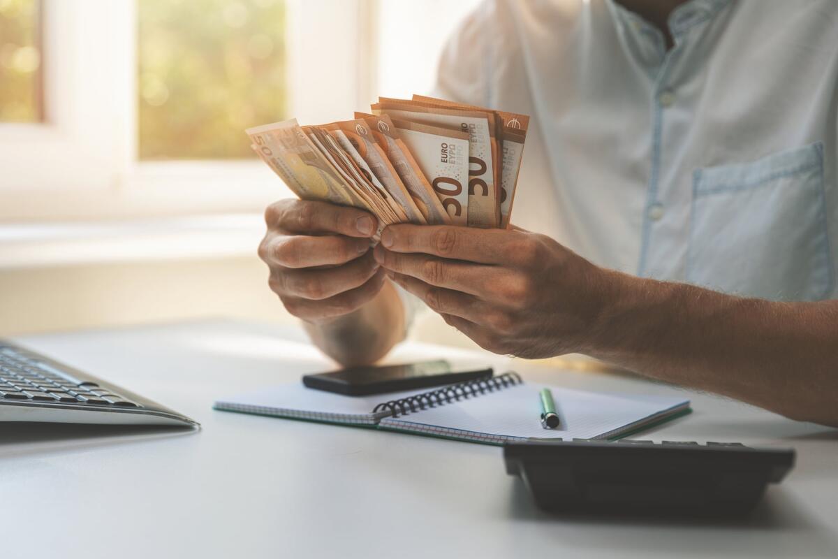 Quale sarebbe uno "stipendio decente" per i giovani italiani? - business success - businessman counting cash money in the office