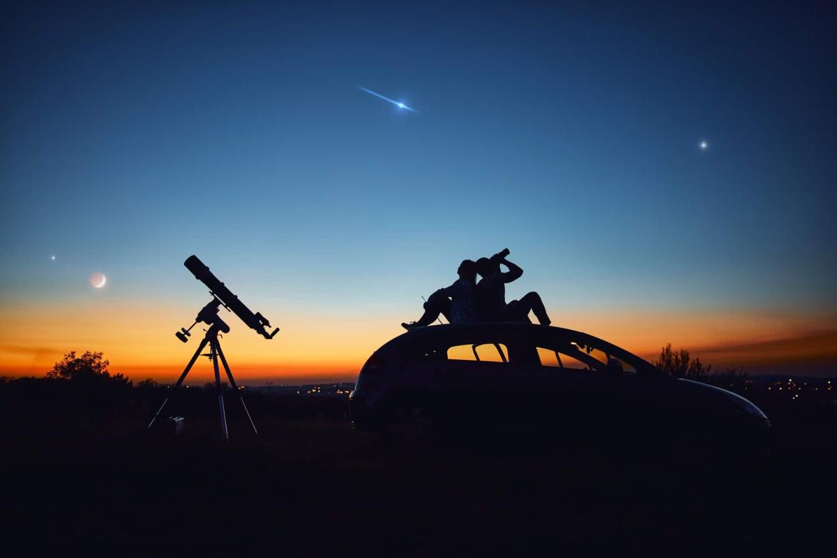 Binocolo astronomico: modelli e come scegliere il migliore - Couple stargazing together with a astronomical telescope.