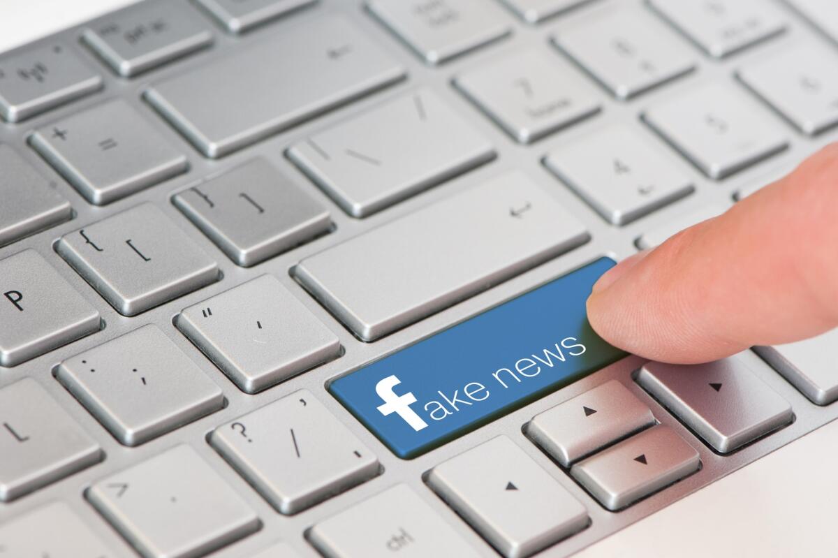 Nuova Bufala su Facebook: "Sto disattivando e non autorizzo" - EVPATORIA, CRIMEA, UKRAINE, MARCH,12,2018 - key with text Fake News on white laptop keyboard. Facebook style.