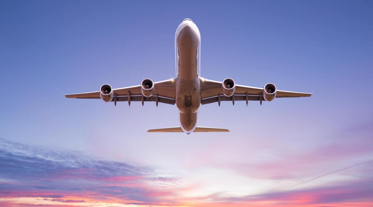 Riattaccata o Go-Around: cos'è e perché è una manovra sicura - Commercial airplane flying above dramatic clouds during sunset.