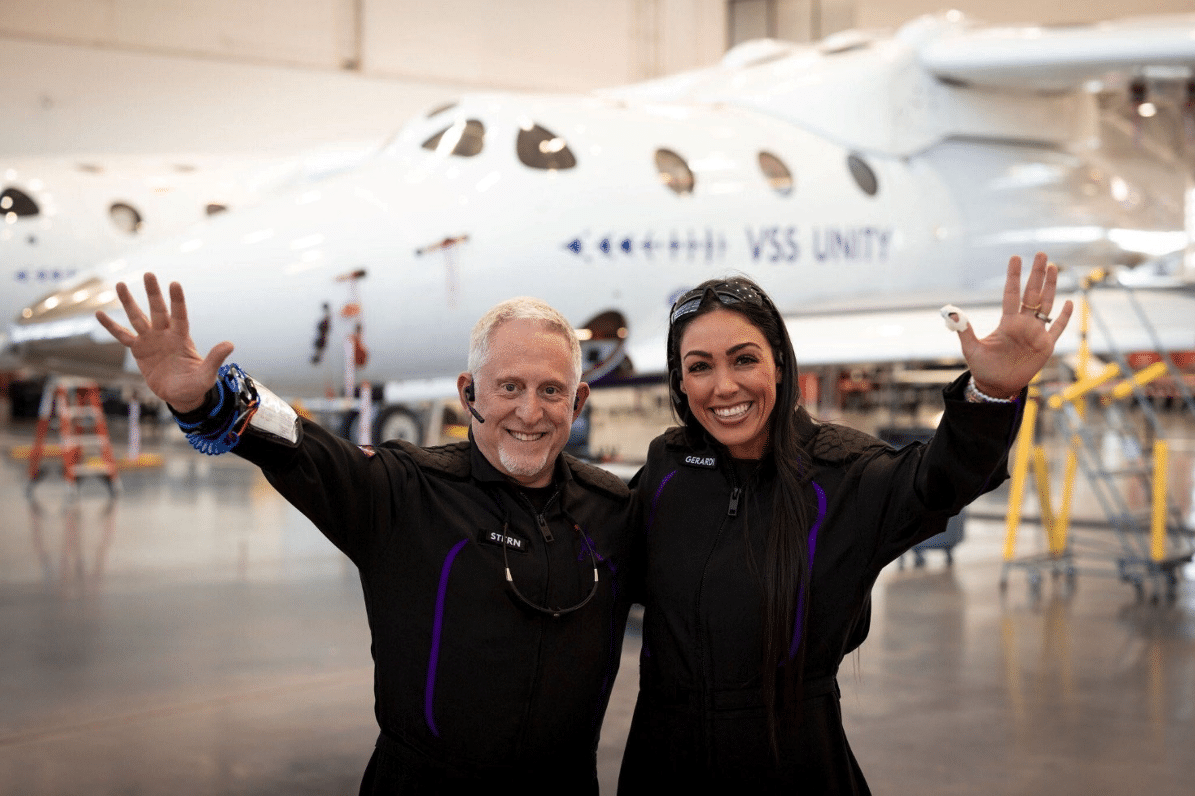 Alan Stern (sinistra) and Kellie Gerardi (destra) di fronte all'aereo VMS Eve di Virgin Galactic