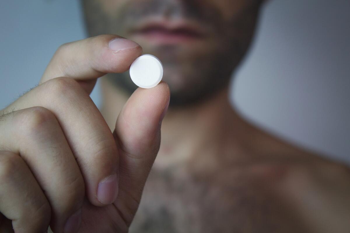Al via il test della pillola anticoncezionale maschile senza ormoni nel Regno Unito - Man holding a pill.