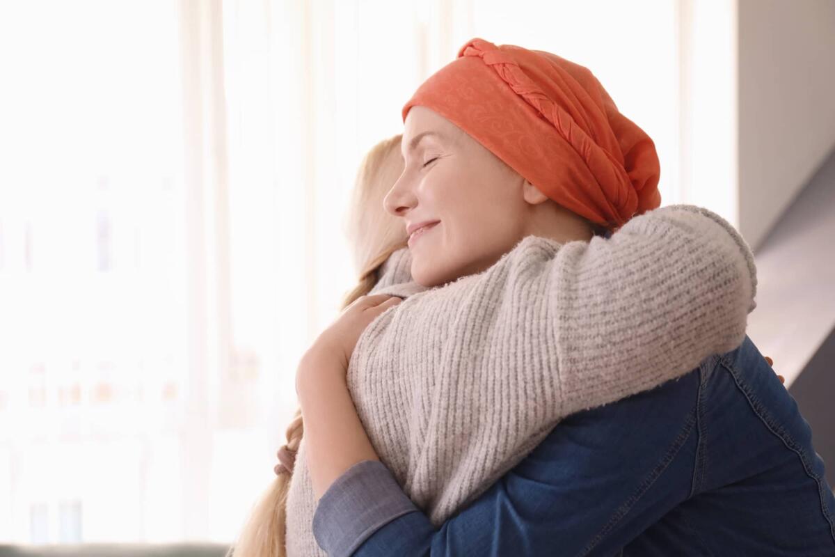 Diritto all’oblio oncologico: una rivoluzione legislativa per i guariti da tumore - Young woman with cancer hugging her mother indoors