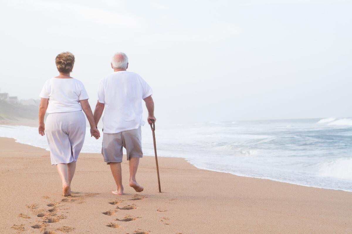 Zone blu: cosa sono e perché sono regioni di interesse - senior couple hand in hand walking on beach