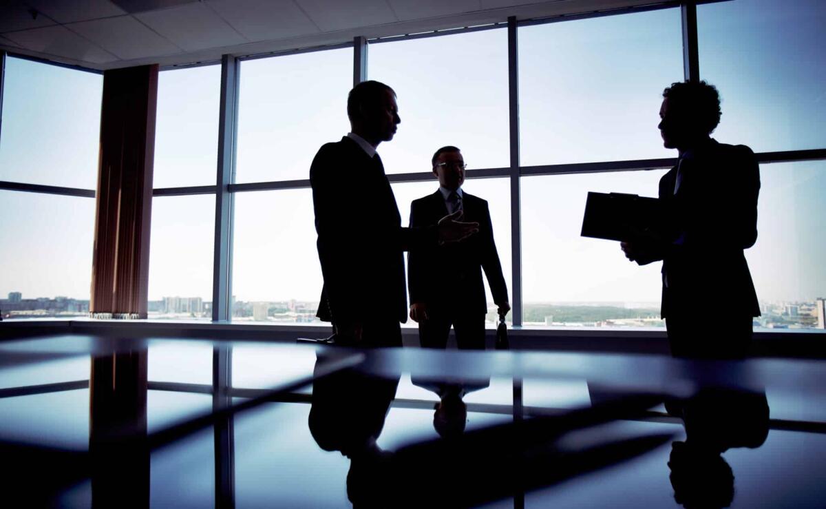 Leadership aziendale in Italia: solo il 2% di under 40 nei CdA - Shady image of a manager discussing business matters with her subordinates
