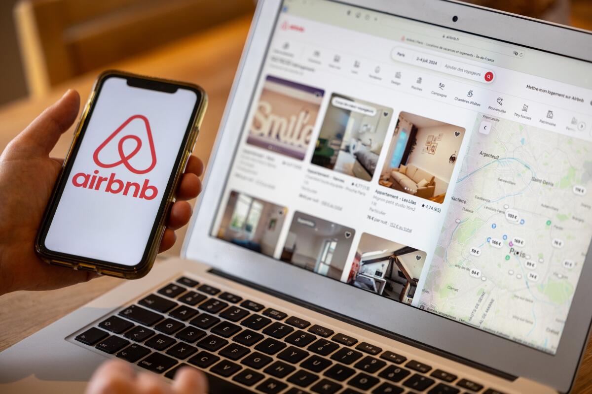 Airbnb pagherà 576 milioni all'Agenzia delle Entrate e diventerà sostituto d'imposta - Paris,  France - November 30, 2023 : Female hand holding smartphone with Airbnb application. Airbnb is an online marketplace and hospitality service, enabling people to lease or rent short-term lodging