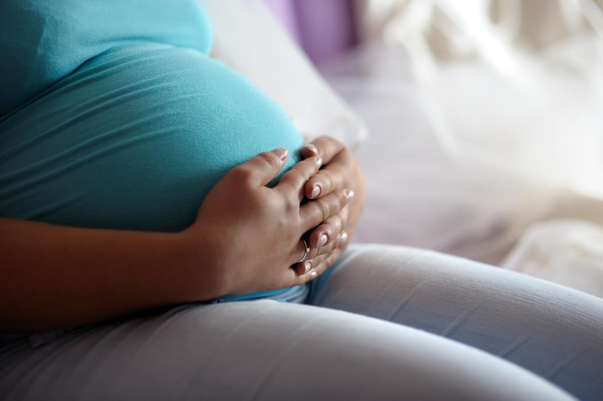 Sindrome di Edwards: cos'è, diagnosi, trattamento, aspettative di vita - Young mother putting her hands on pregnant belly