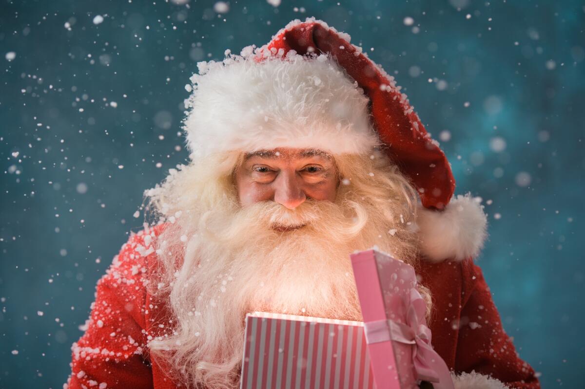 Secret Santa: come evitare di prendere il proprio nome durante il sorteggio - Happy Santa Claus opening his Christmas gift at North Pole