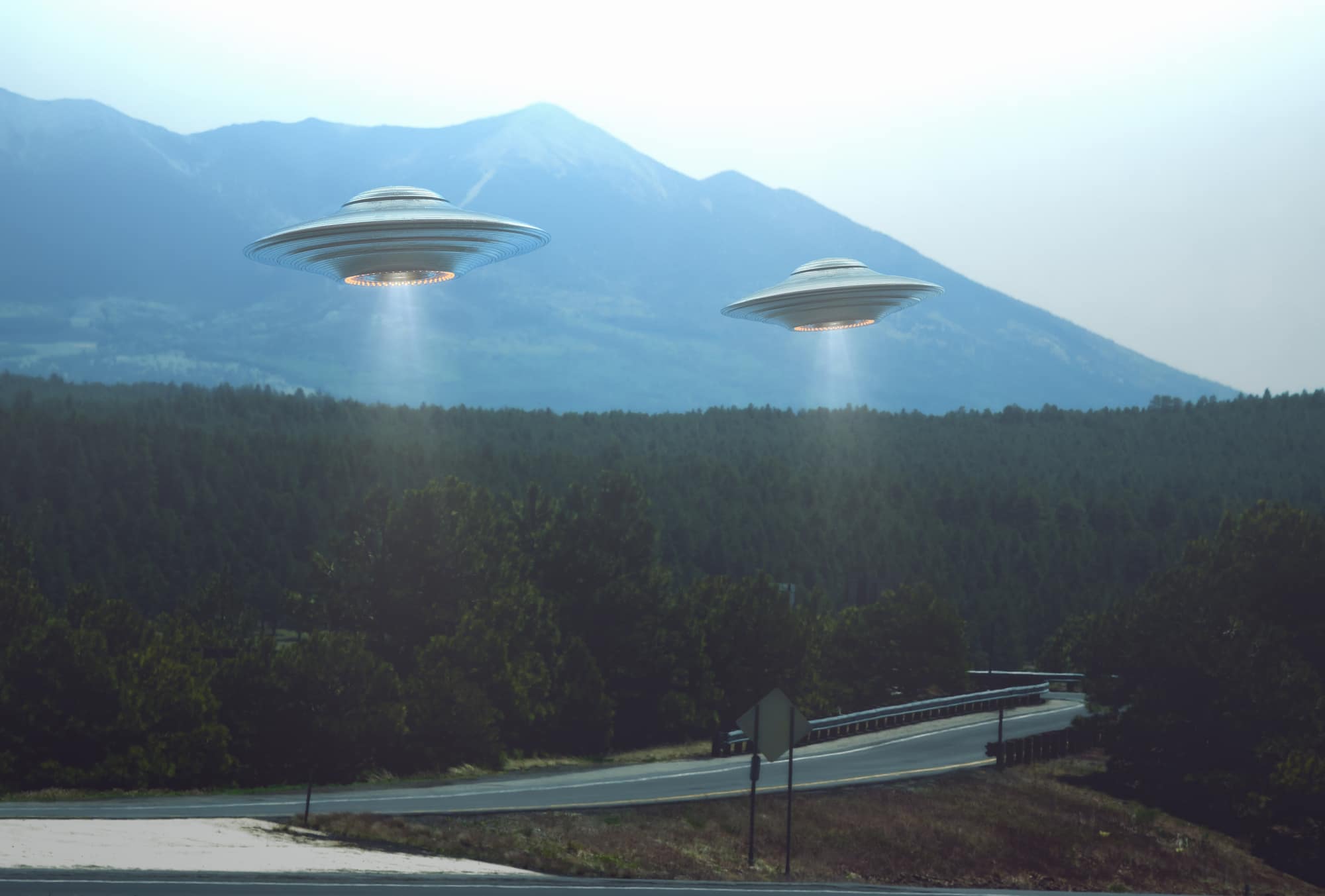 Unidentified flying object. Two UFOs flying over a road among the trees. 3D illustration.