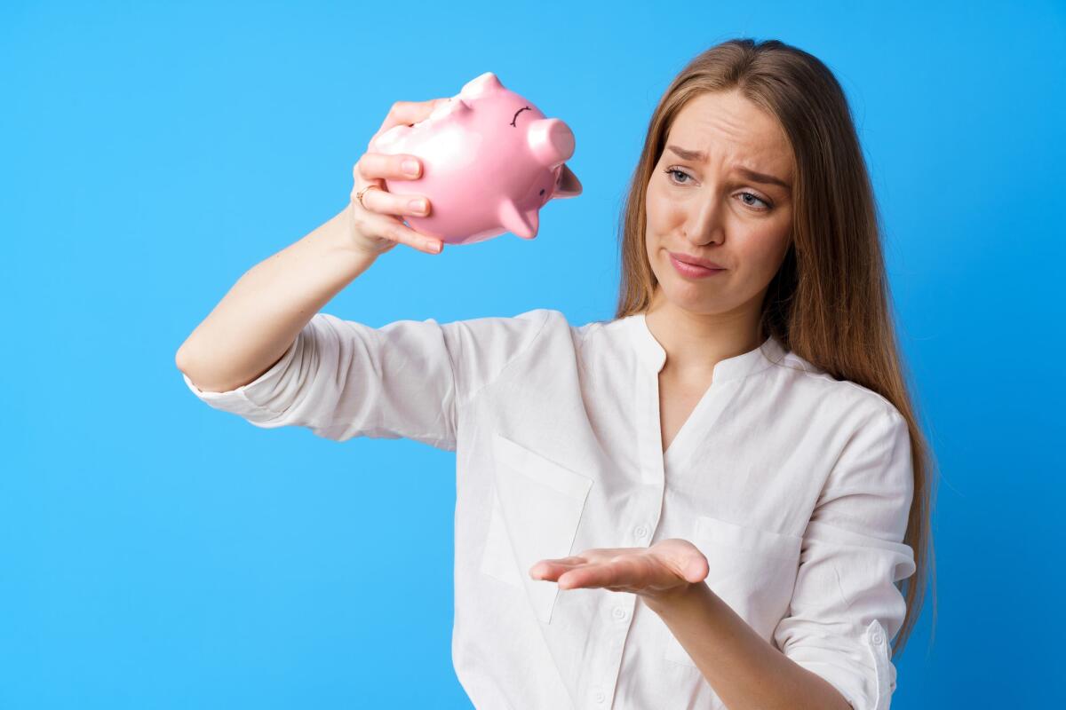 Nuova Legge di Bilancio 2024: solo il 3% per i giovani - Unhappy woman holding piggy bank moneybox against blue background, close up