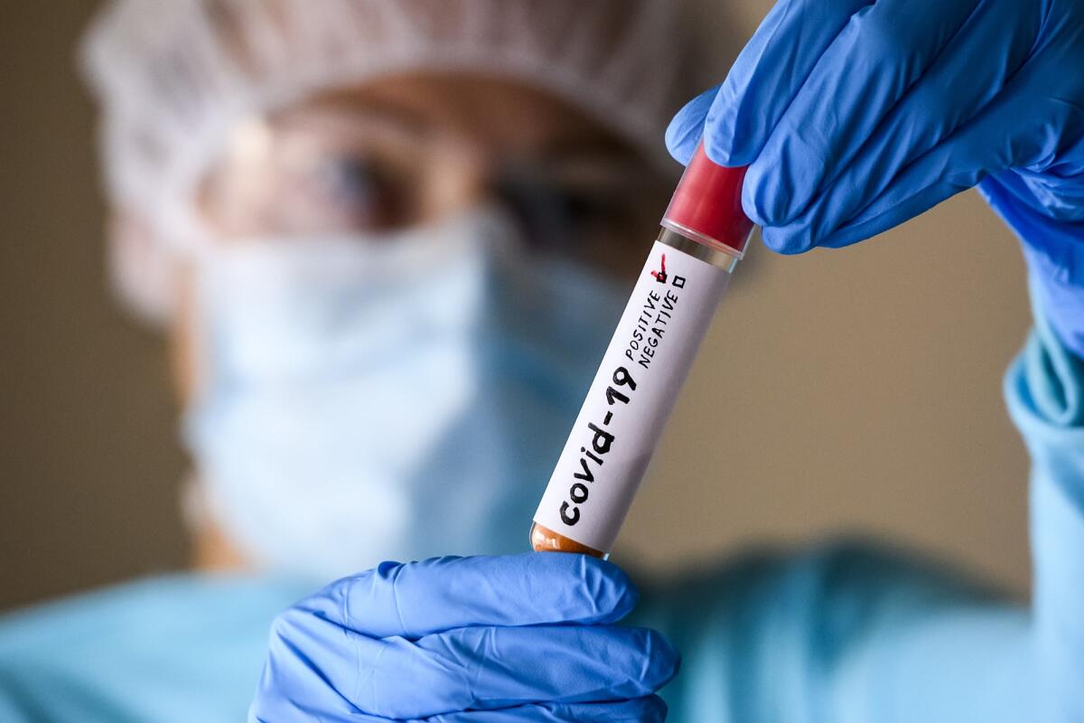 La sequenza genetica del Coronavirus è stata individuata due settimane prima della notifica ufficiale del governo cinese - Woman in protective suit hold test tube with positive result infected with coronavirus COVID - 19. Photo Illustration.