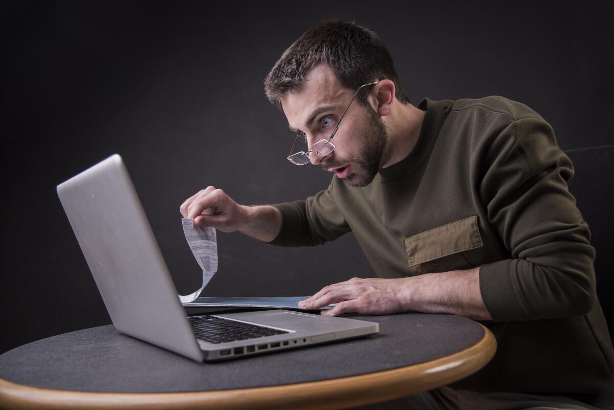 I giovani rischiano di avere una pensione pari a metà dello stipendio - Young man is in shock with his finances and reports, screaming at his laptop
