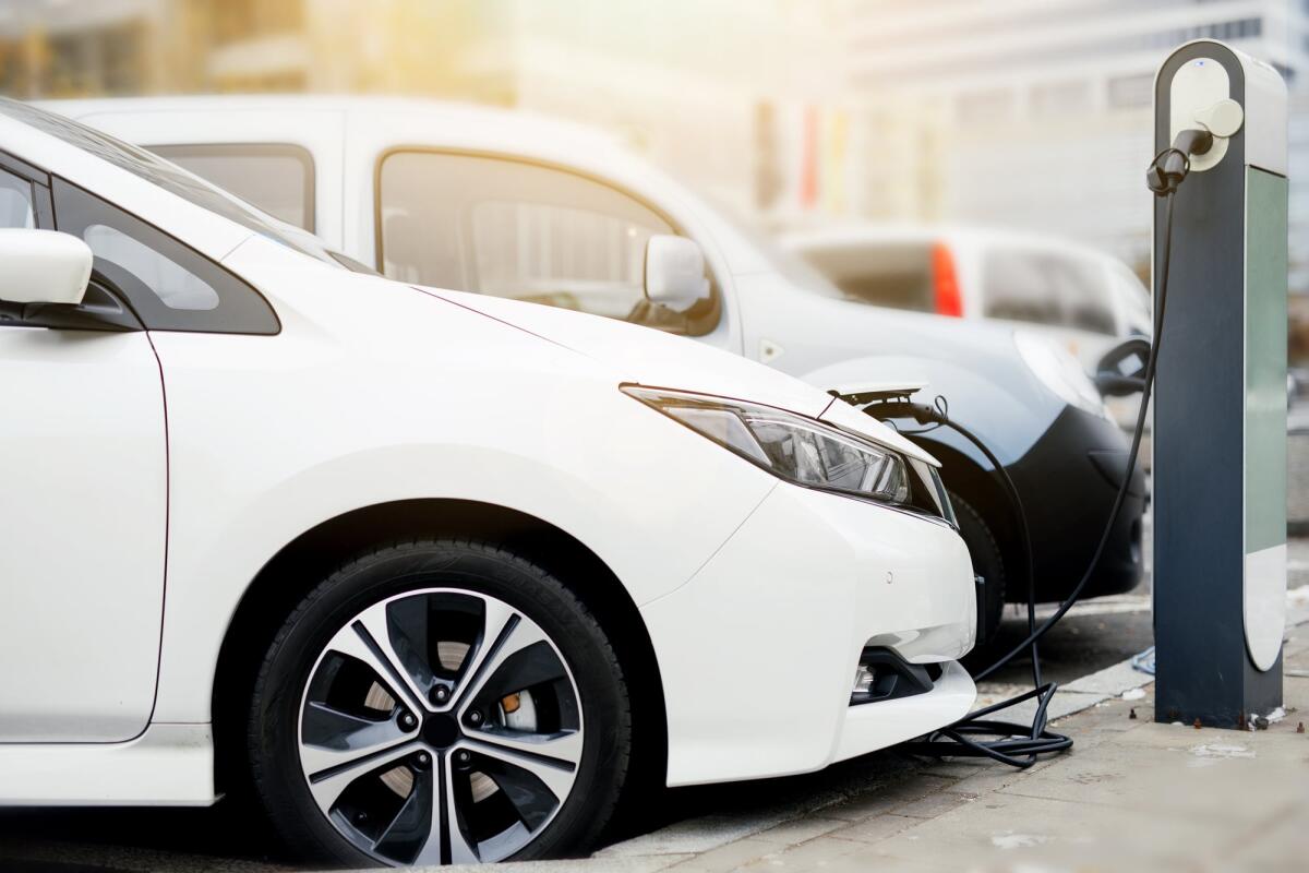 Il Regno Unito invita a usare con cautela il termine "emissioni zero" nelle campagne pubblicitarie automobilistiche - Electric car charging station. Close up of the power supply plugged into an electric car being charged. - Image