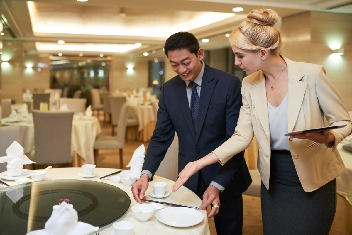Come diventare wedding planner: formazione, competenze richieste e adempimenti burocratici - Wedding planner and banquet manager discussing table setting