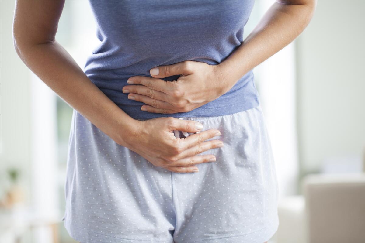 La diagnosi precoce del cancro ovarico potrebbe essere fatta con un test delle urine - Young woman having painful stomach ache. Chronic gastritis. Stomach or menstrual cramps. Abdomen bloating concept.
