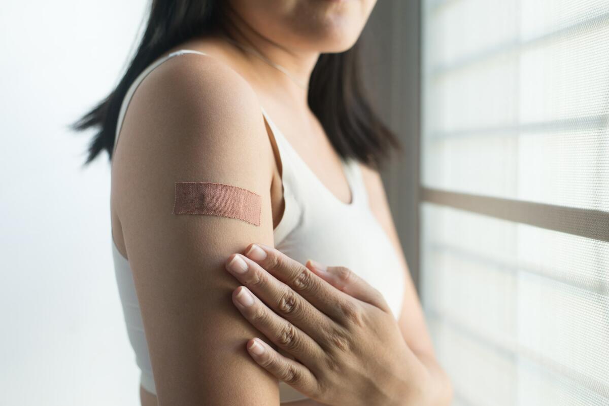Come sono stati inventati i cerotti? - Woman using adhesive bandage plaster on her arm after injection vaccine