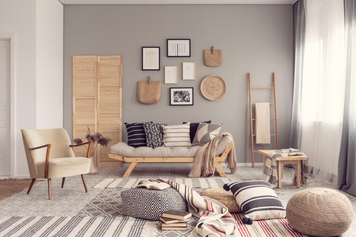Design di interni: i trend del momento - Stylish living room interior design with scandinavian settee, grey wall and natural accents