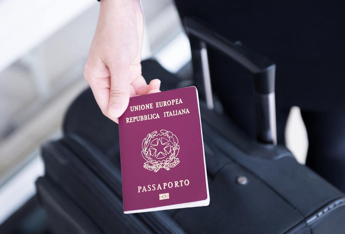 Passaporto: da luglio richiesta e rinnovo presso uffici postali di tutta Italia - Hand holding Italy passport, ready to travel