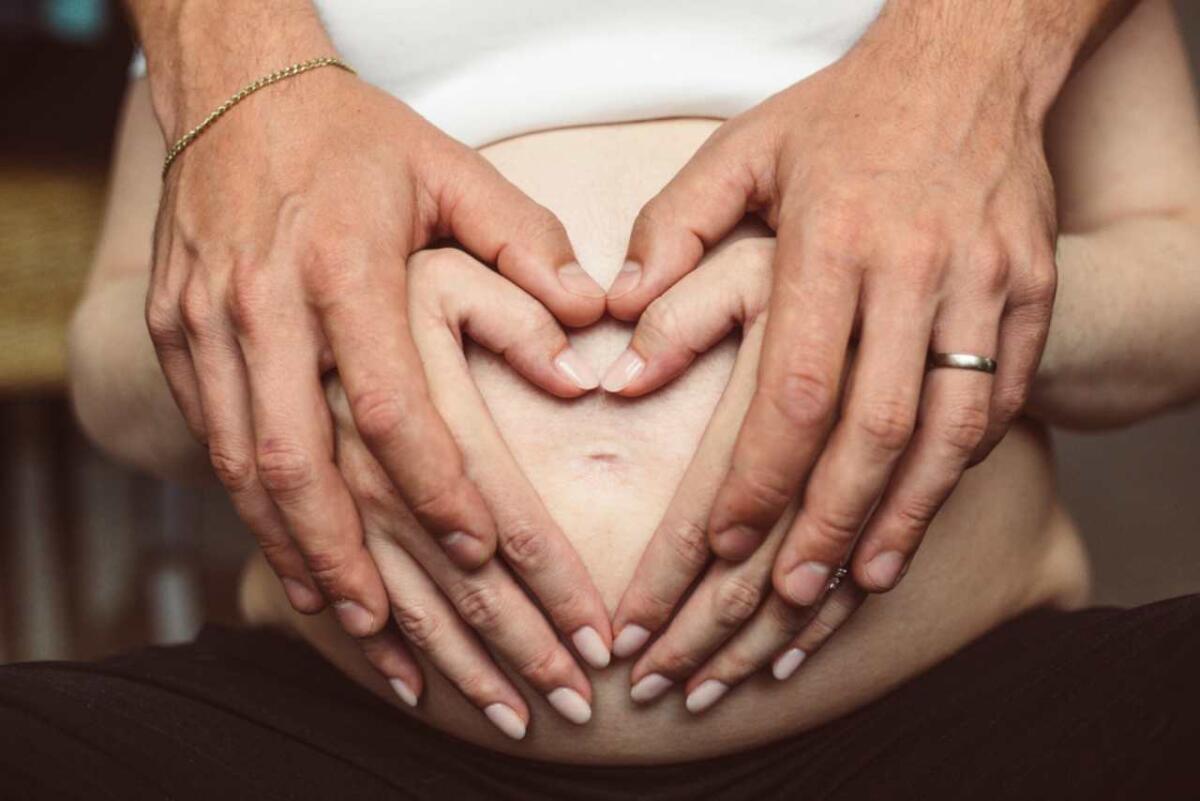 Acido folico in gravidanza: perché ne viene consigliata l’assunzione - Man and woman hands on the pregnant belly
