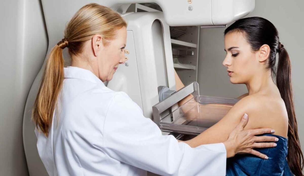 Un modello di AI riesce a identificare il tumore al seno anni prima che si sviluppi - Medico e paziente mammografia con apparecchio (Depositphotos foto) - www.biomedicalcue.it