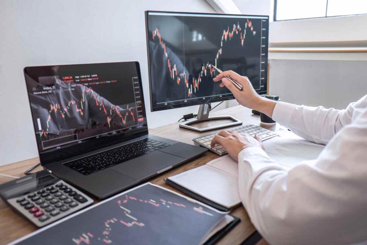 I vantaggi del trading automatico - Stock exchange market concept, Business investor trading or stock brokers having a planning and analyzing with display screen and pointing on the data presented and deal on a stock exchange.