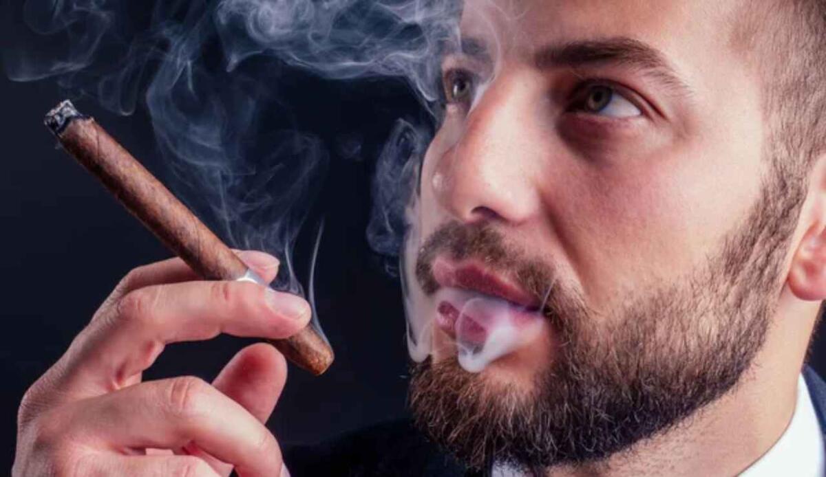 Meno sigarette, più guadagni: fumare penalizzerebbe i lavoratori - Illustrazione di una persona che sta fumando (Depositphotos FOTO) - www.managementcue.it