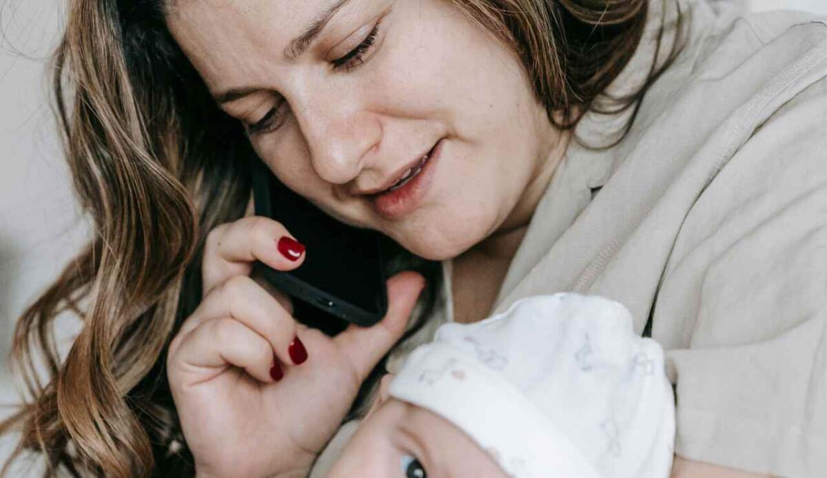 L’apprendimento del linguaggio inizia prima del previsto: i neonati elaborano suoni e immagini a 4 mesi - Mamma che parla con un neonato in braccio (Canva Foto) - www.sciencecue.it
