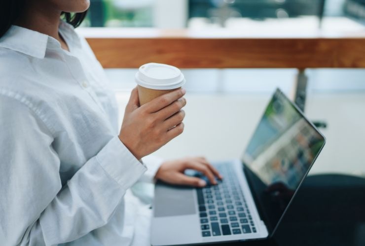 Lavoratrice al PC con il caffè (Canva Foto) - www.managementcue.it