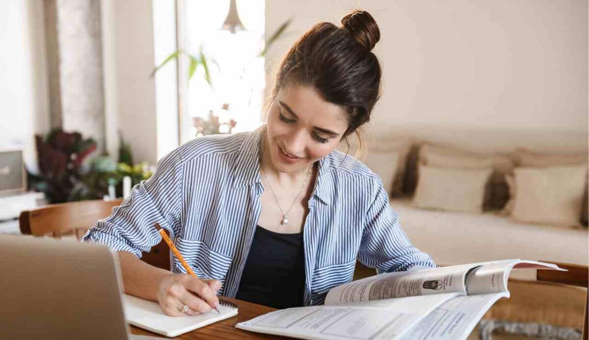 Studiare senza pensieri: "Per Merito" ti sostiene durante il percorso formativo - Persona che studia e sorride (Canva foto) - www.financecue.it