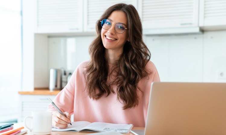 Persona sorridente che studia (Canva foto) - www.financecue.it