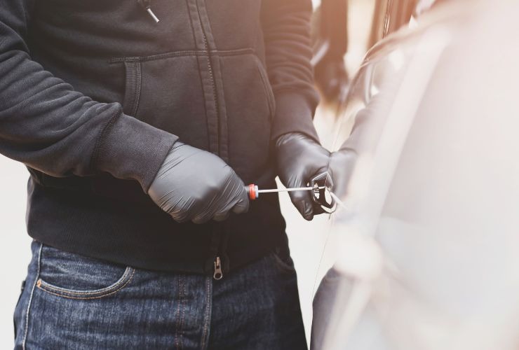 Ladro che cerca di forzare un'auto (Canva Foto) - financecue.it