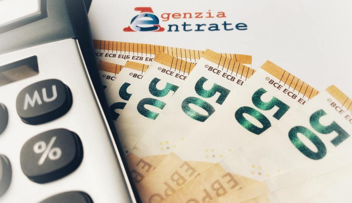 Stop ai rimborsi fiscali per chi ha debiti con il Fisco: le novità del 2025 - Provìnce of Florence, Italy - January 14th 2024 - Letter from the revenue agency (agenzia delle entrate) with a calcultator and fifty euro banknotes . Concept of Italian Taxes .