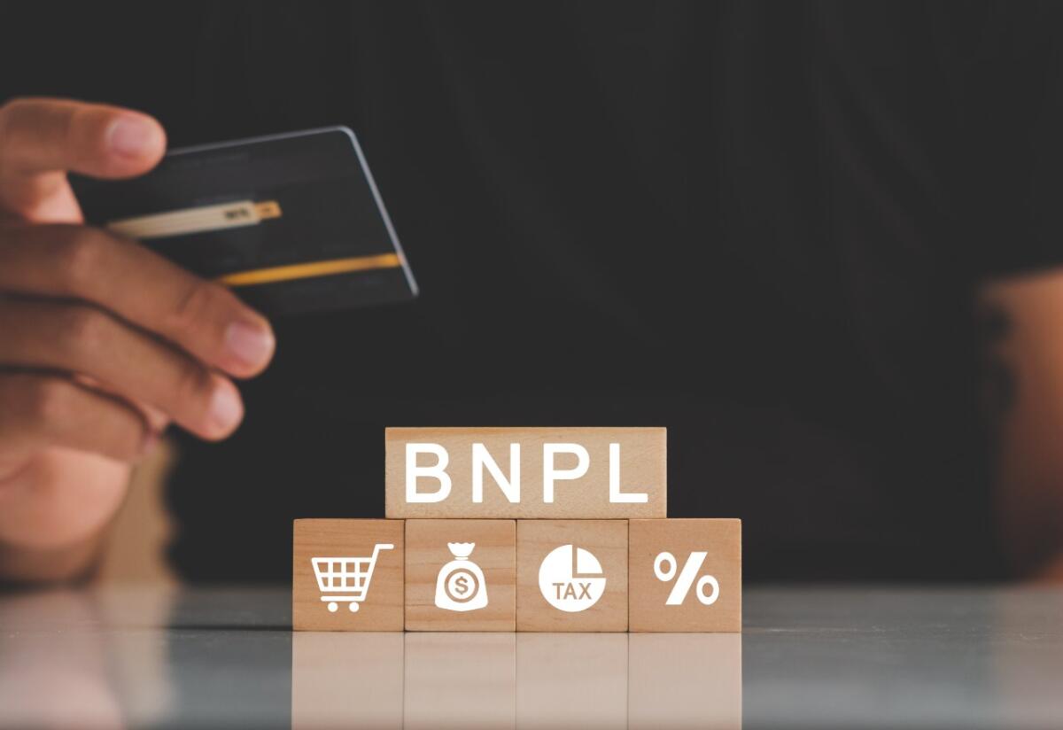 Come il Buy Now Pay Later è diventato popolare nella Generazione Z - Man's hands holding credit card with BNPL icons. Buy now pay later online shopping concept. Online shopping icons.