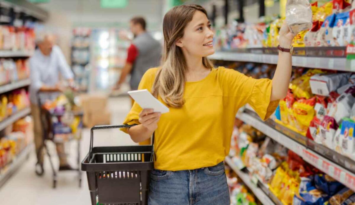 Perché al supermercato i prodotti più costosi sono sempre all’altezza degli occhi? - Illustrazione di una ragazza al supermercato (Canva FOTO) - managementcue.it