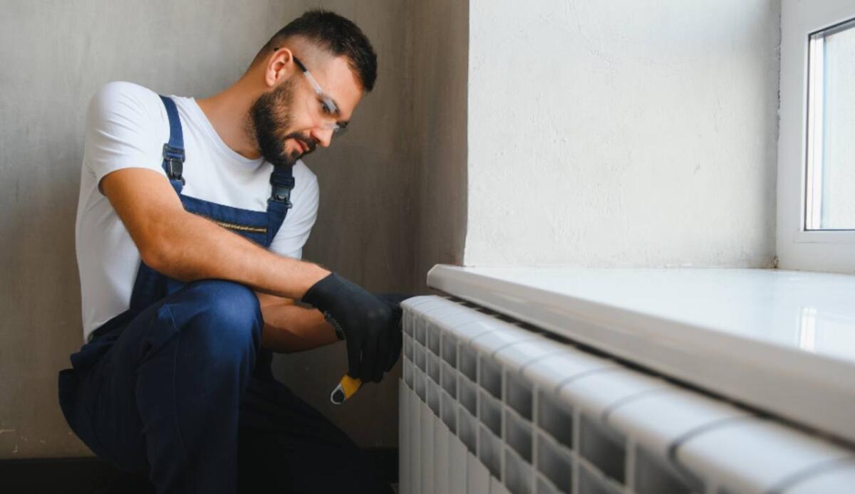 Rinnova i tuoi termosifoni fai da te: guida completa passo dopo passo - Illustrazione della manutenzione di un termosifone (Canva FOTO) - buildingcue.it